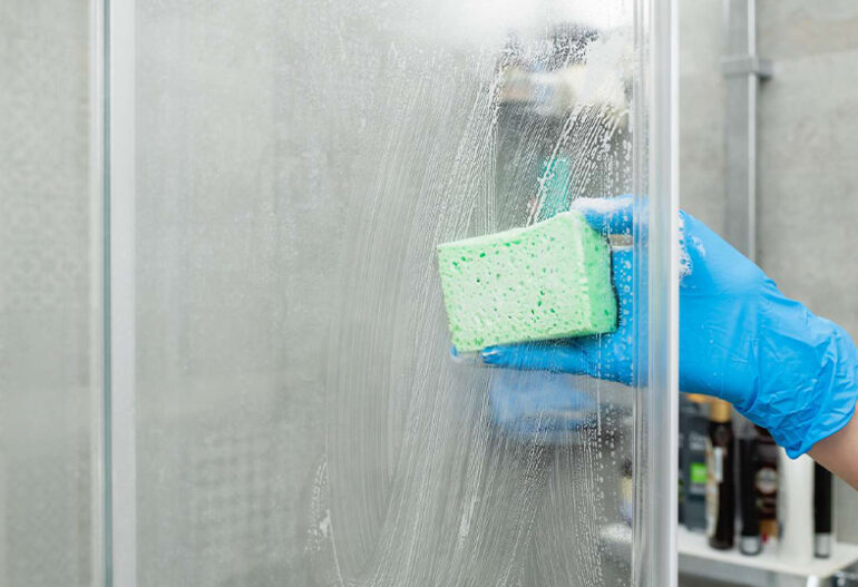 How can I effectively remove soap scum and hard water stains from my shower doors